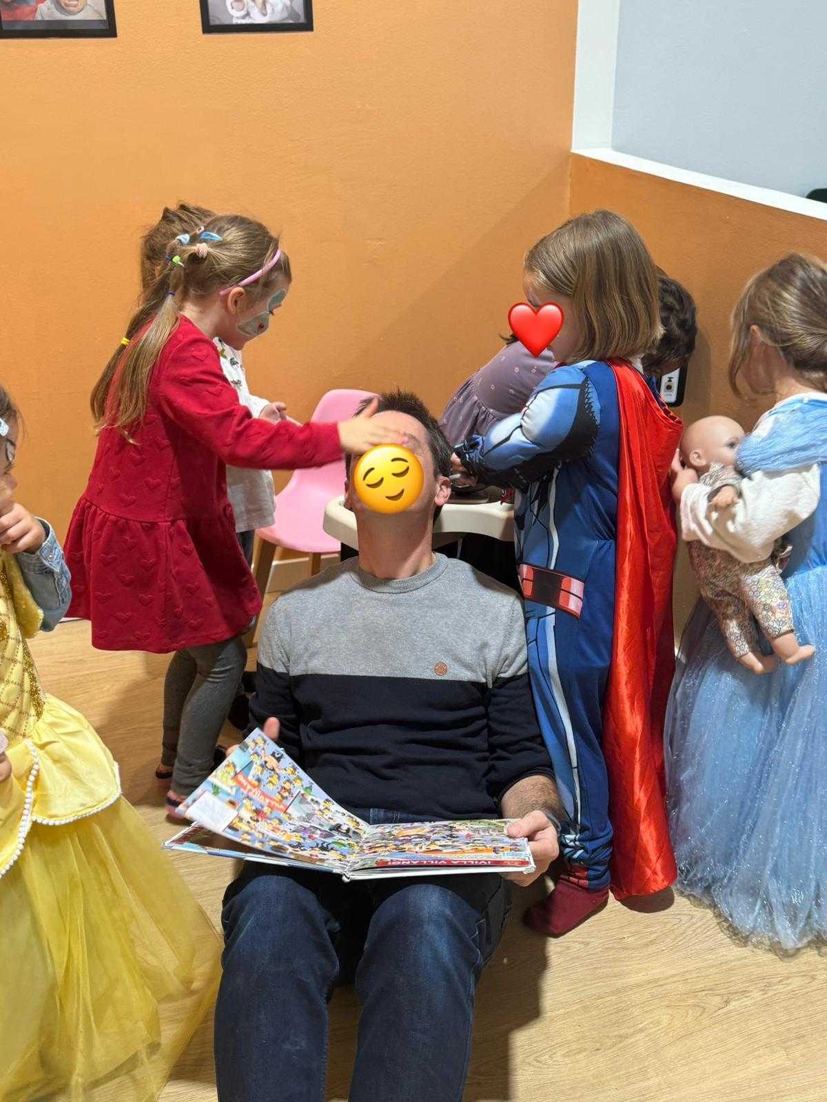 Un padre paciente rodeado de amor infantil, disfrutando de un momento mágico con sus pequeñas princesas y superhéroes.